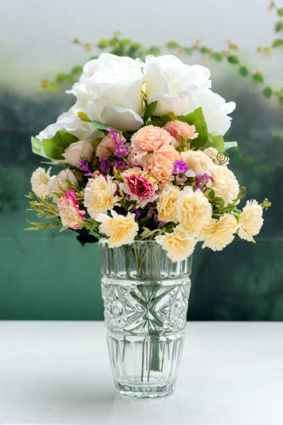 istock flower in glass vase on white table 1047901326