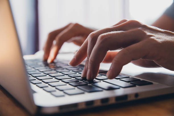 istock Close up fingers typing on the computer keyboard,pressing buttons, typing, simple close up with lens flare 1047947964