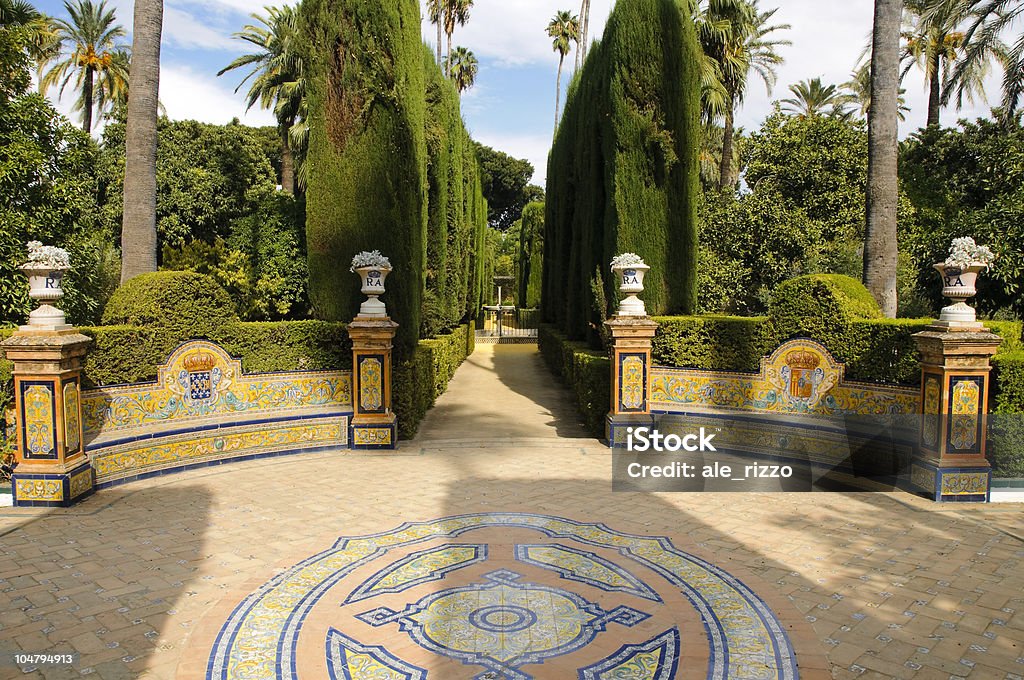 Garden of the Royal Alcazar in Seville, Spain Small quiet square with decorated floor and narrow walkway in the gardens of the Royal Alcazar in Seville. Andalusia Stock Photo