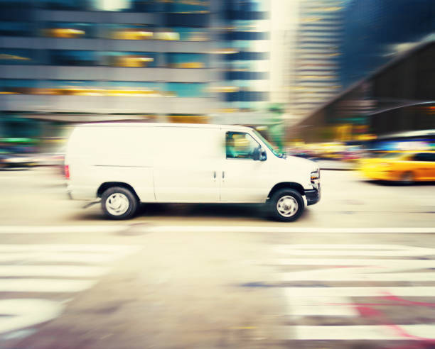 istock Commercial white van speeding in New York 1047951048