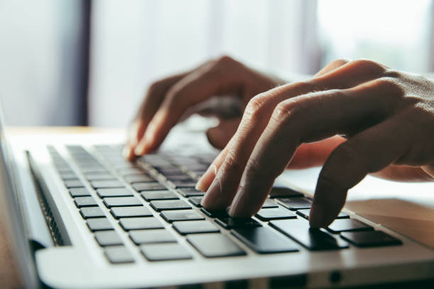 istock Close up fingers typing on the computer keyboard,pressing buttons, typing, simple close up with lens flare 1047951234