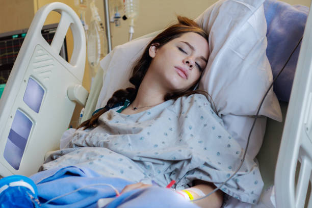 Teen mother labors in hospital bed during childbirth Caucasian teenage girl has her eyes closed as she is lying in a hospital bed during childbirth. Young pregnant mother is preparing to have her first baby. sick woman hospital bed stock pictures, royalty-free photos & images