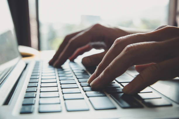 istock Close up fingers typing on the computer keyboard,pressing buttons, typing, simple close up with lens flare 1047961592