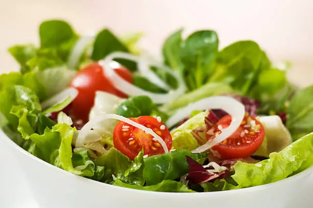 Fresh green salad with tomato and onion close up