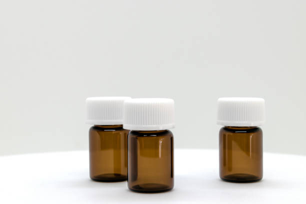 istock Three brown sample bottles with white caps on white background with free space 1047965878