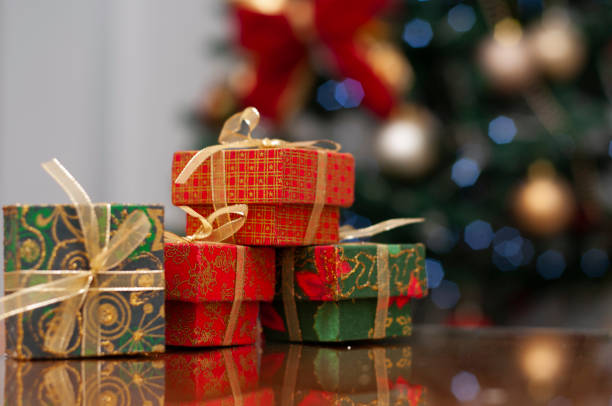 istock christmas present on table with blurred background of christmas tree 1047966362