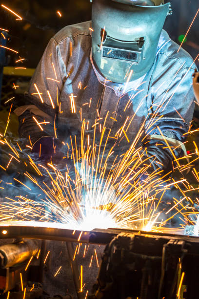 saldatore industriale in acciaio in fabbrica - welding sparks foto e immagini stock