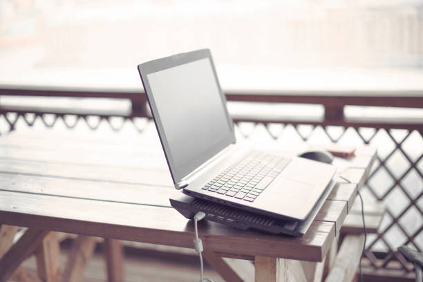 istock Wooden table on the veranda office laptop Internet modern gadget copy space. 1047969080