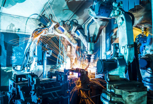 Robots welding in a car factory Welding robots movement in a car factory construction machinery photos stock pictures, royalty-free photos & images