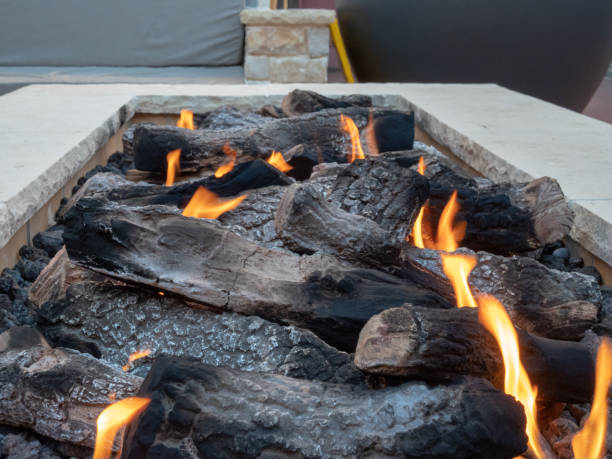 istock Close up of logs burning in a large, white, stone fire pit 1047977650