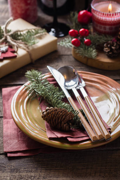 istock Christmas Setting Table. Dinner plate, silverware, fir tree, gift boxe, candle and festive decoration. Holiday Food Concept 1047980832