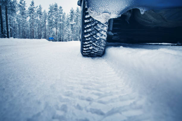 istock Car tires on winter road covered with snow 1047989558