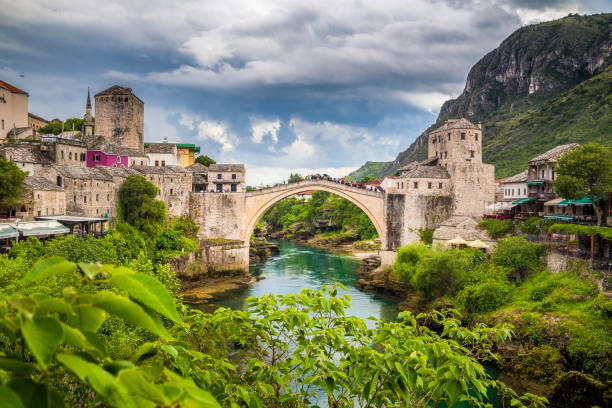 Old town of Mostar with famous Old Bridge (Stari Most), Bosnia and Herzegovina Panoramic aerial view of the historic town of Mostar with famous Old Bridge (Stari Most), a UNESCO World Heritage Site since 2005, on a rainy day with dark clouds in summer, Bosnia and Herzegovina stari most mostar stock pictures, royalty-free photos & images