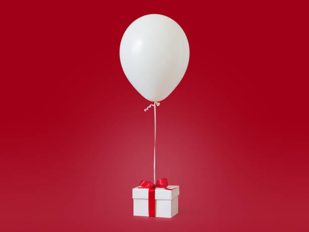 istock White gift box with red ribbon and balloon on red background. 1048005004