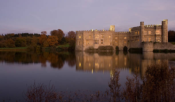 Old English Castle and lake at sunset stock photo