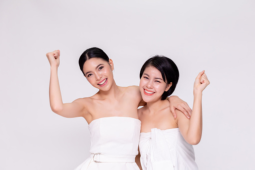 Two pretty and cute cheerful Asian woman with positivity cheering up in white isolated background