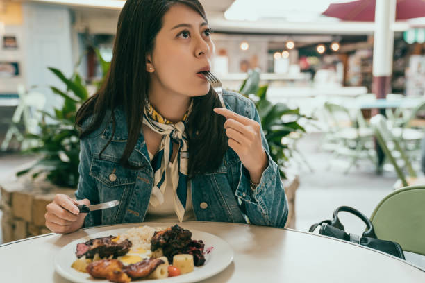 istock beautiful lady sitting outdoor and having lunch 1048028038