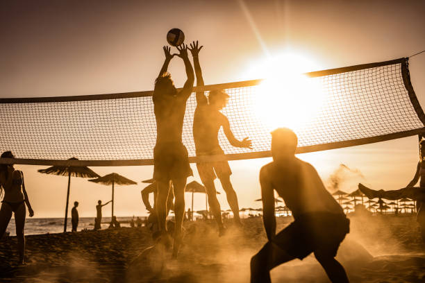 istock Young friends having fun while playing beach volleyball at sunset. 1048051902