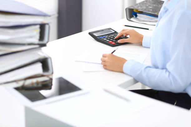 istock Unknown female bookkeeper or financial inspector calculating or checking balance, making report, close-up. Internal Revenue Service at work with financial document. Tax and audit concept. 1048060464