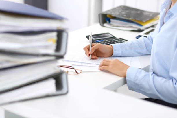 istock Unknown female bookkeeper or financial inspector calculating or checking balance, making report, close-up. Internal Revenue Service at work with financial document. Tax and audit concept. 1048060486
