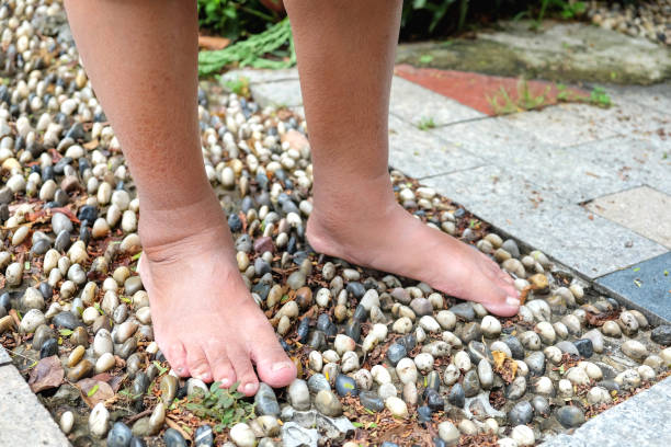 Mature men walking barefoot on stones path