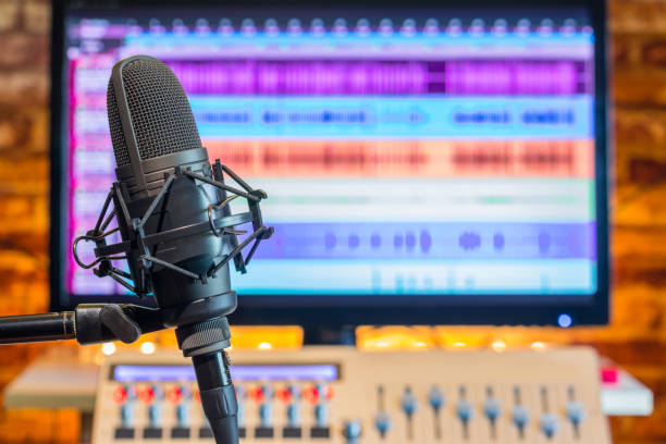 istock condenser microphone on screen and digital sound mixer background. recording, broadcasting concept 1048078644