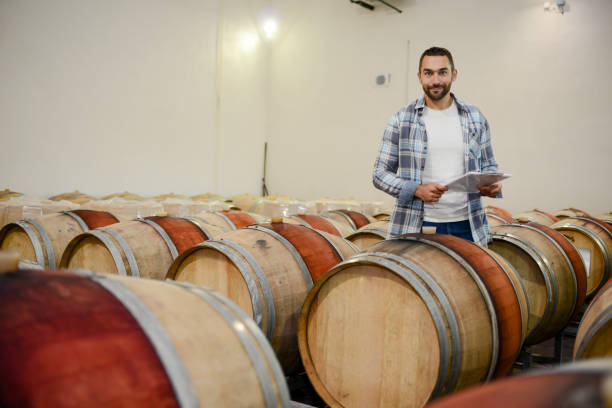 istock handsome man winemaker in a maturing wine cellar winery during harvest season with oak barrels 1048078928