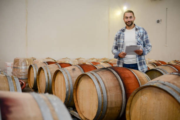 istock handsome man winemaker in a maturing wine cellar winery during harvest season with oak barrels 1048078946