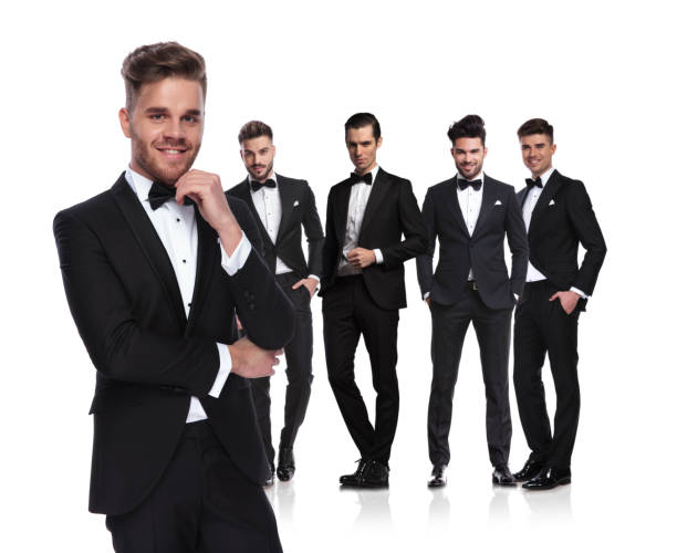 istock young group leader in tuxedo stands in front and smiles 1048086978