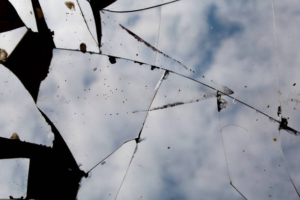 Broken mirror with abstract blue background with reflection of cloudy sky