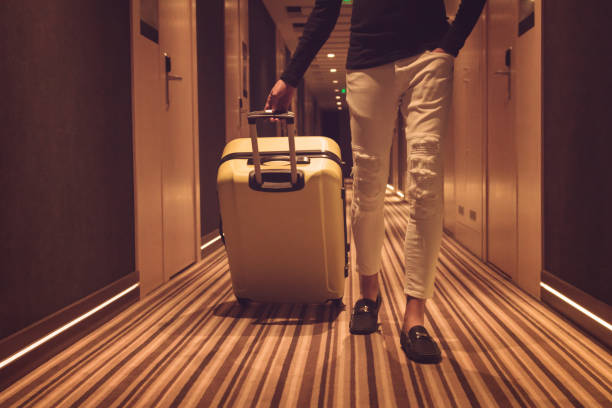 istock Unrecognizable man with suitcase walking through hallway. 1048088682