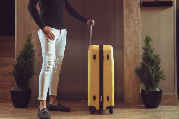 istock Unrecognizable man with travel bag waiting by elevator in the hallway. 1048089026