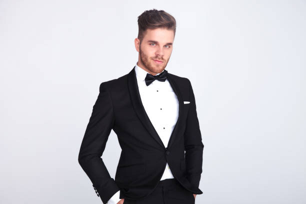 istock smiling man in black tuxedo standing with hands in pockets 1048089188