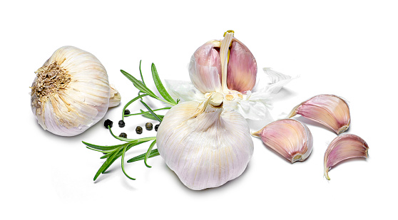 Beautiful fresh garlic with black peppercorns and rosemary branches. Group of objects or cooking ingredients, isolated on white background. Closeup shot, top view.