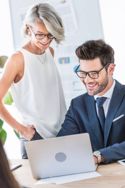istock young smiling businesspeople looking at laptop in office 1048094706