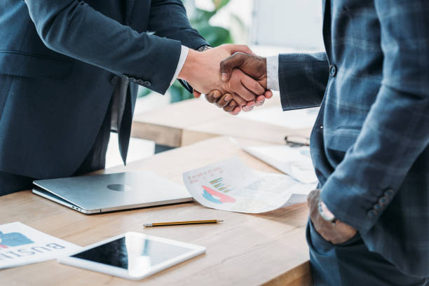 istock cropped image of multicultural businessmen shaking hands in office 1048094836