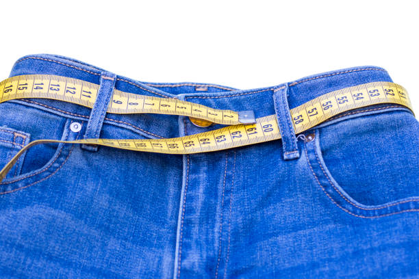 jeans e soggetto di misura per la perdita di peso su sfondo bianco - remote fat overweight dieting foto e immagini stock