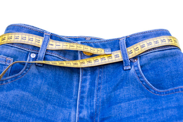 jeans and measuring subject for weight loss on white background - remote fat overweight dieting imagens e fotografias de stock