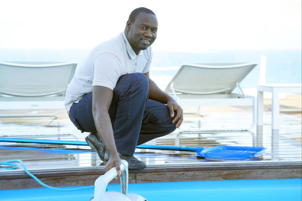 Hotel staff worker cleaning the pool
