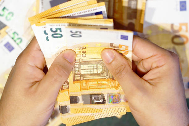 istock Hands hold and counting euro banknotes 1048099254