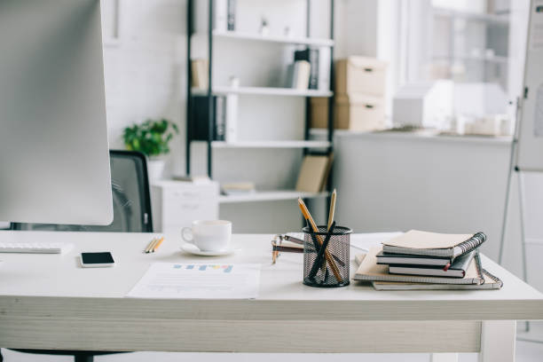 istock pen holder, cup of coffee and smartphone on table in light modern office 1048099368