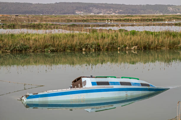 Sunken fishing boat On the Slovenian cycle path of the Parenzana railway from Portoroz to the Croatian border - countless colorful fishing and sailing boats float idyllically on a canal fishing boat sinking stock pictures, royalty-free photos & images