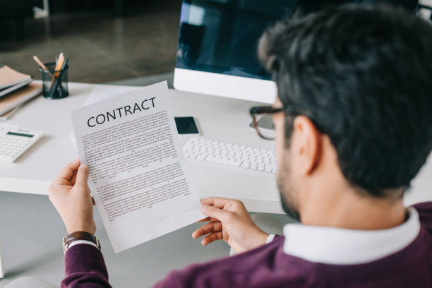 istock back view of businessman reading contract in office 1048099554