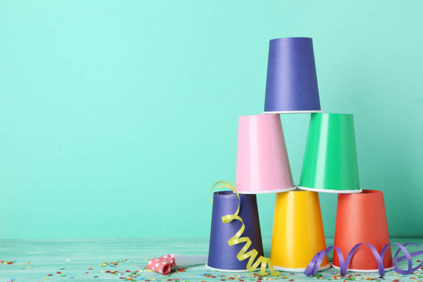 istock Colorful paper cups with confetti and blower on mint background 1048103664