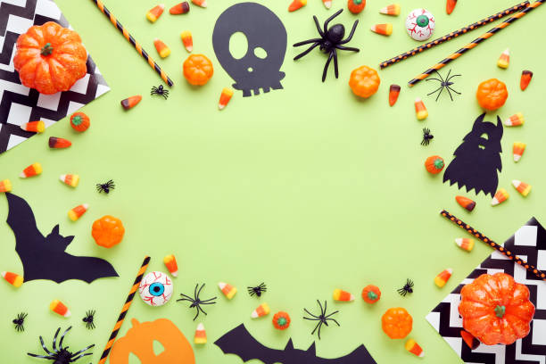 istock Halloween candies with paper decorations on green background 1048110852