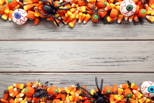 istock Halloween candy corns with black spiders on wooden table 1048114458