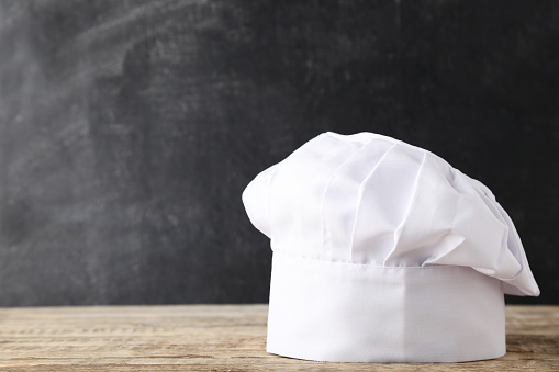 Chef hat on wooden table
