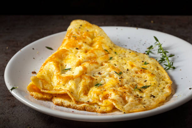 Scrambled eggs or omelette made from eggs and cheese with herbs stock photo