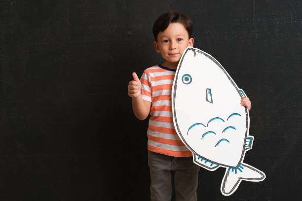 istock Cute child holding fish drawing. 1048137054