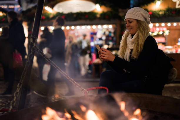 istock Young blondie female relaxing whit mobile next to fireplace. 1048141704